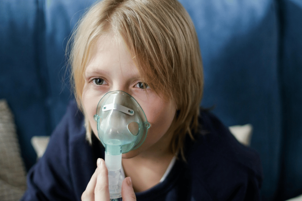 Seorang anak sedang menggunakan nebulizer