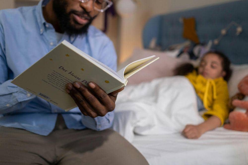 Papa membacakan buku cerita agar anak tidur teratur