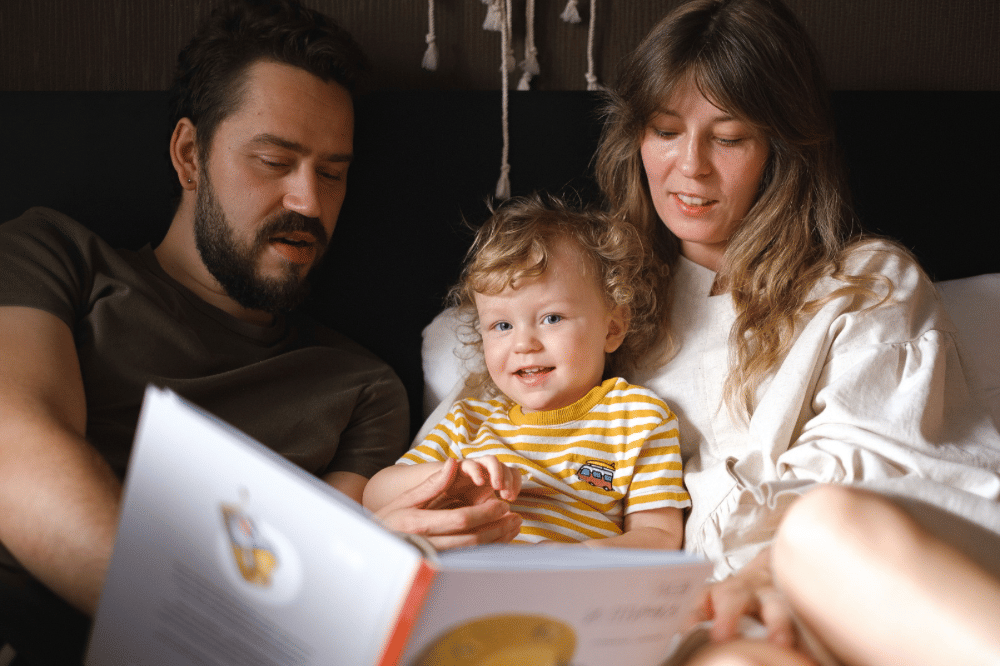 Papa, Mama, dan sang anak membaca buku bersama