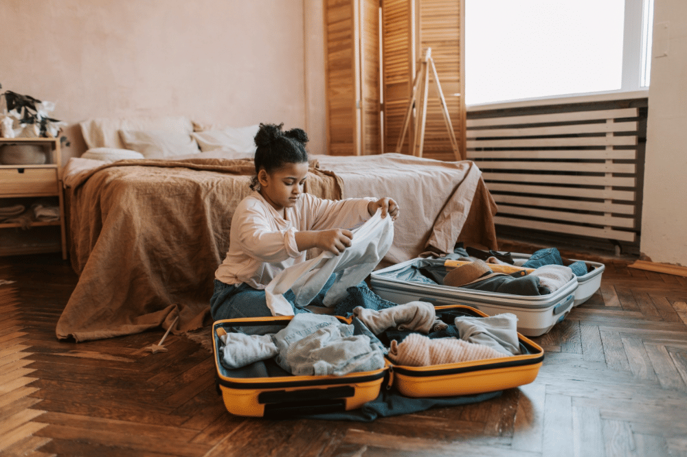 Seorang anak sedang packing baju