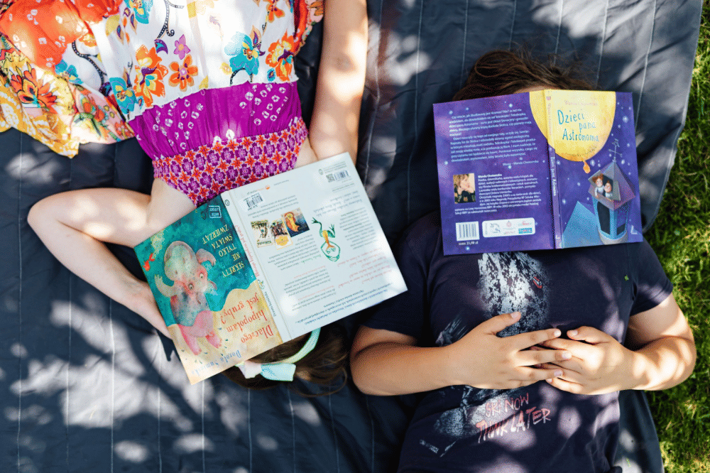 Dua orang anak tertidur dengan wajah tertutup buku