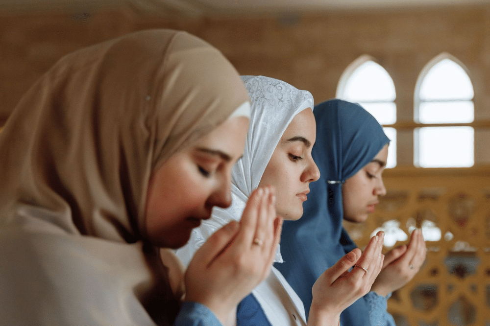 Tiga perempuan sedang berdoa bersama