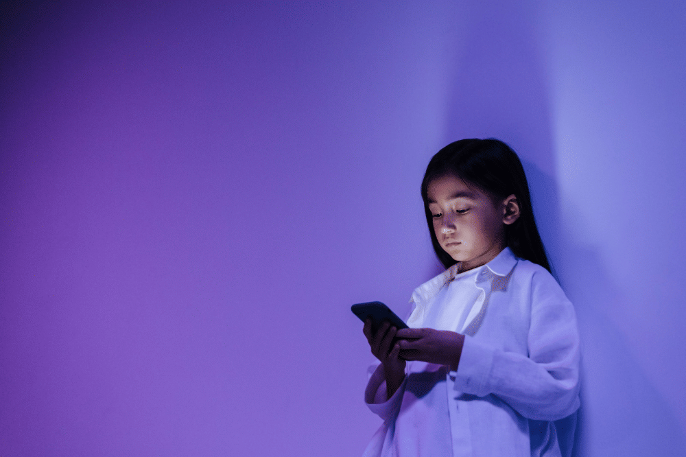 Seorang anak sedang bermain handphone