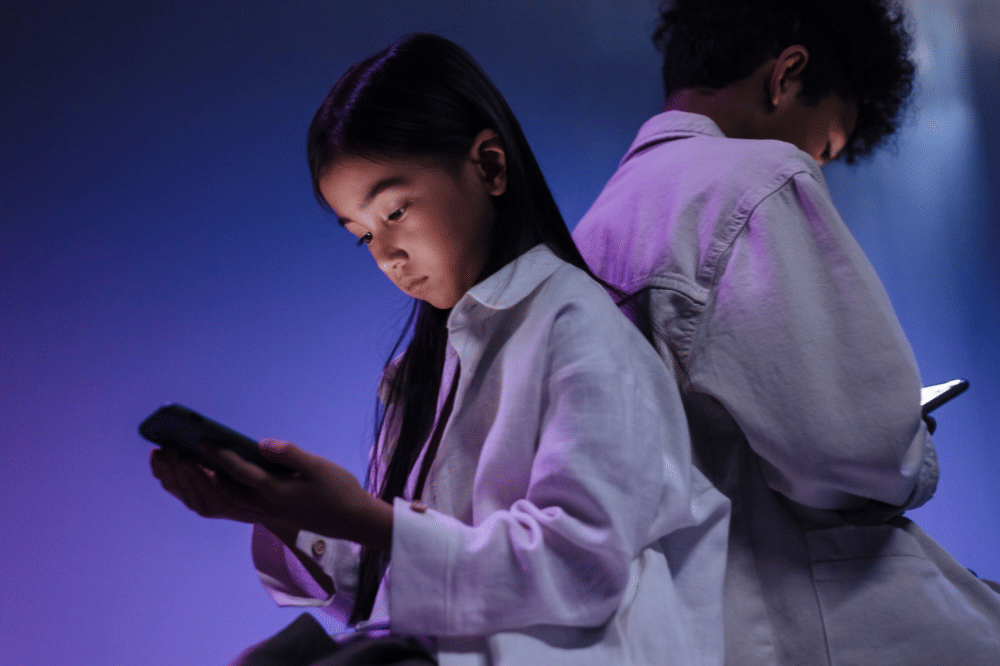 Dua orang anak sedang bermain gadget