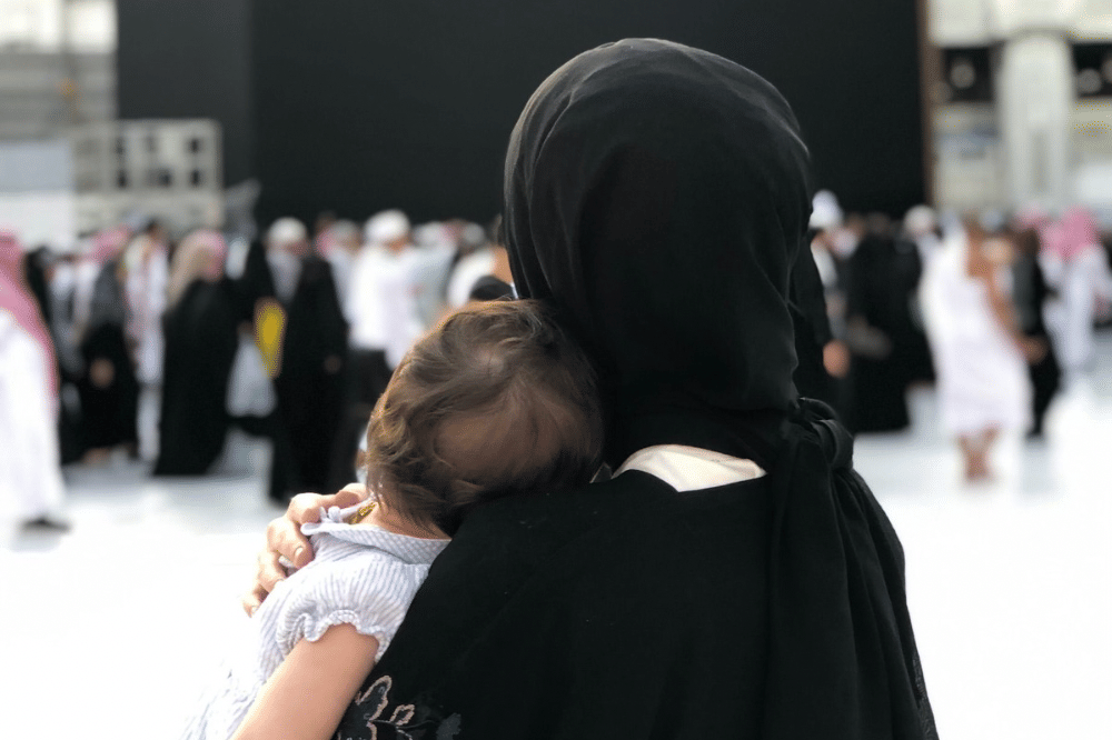 Mama menggendong sang anak saat beribadah haji 