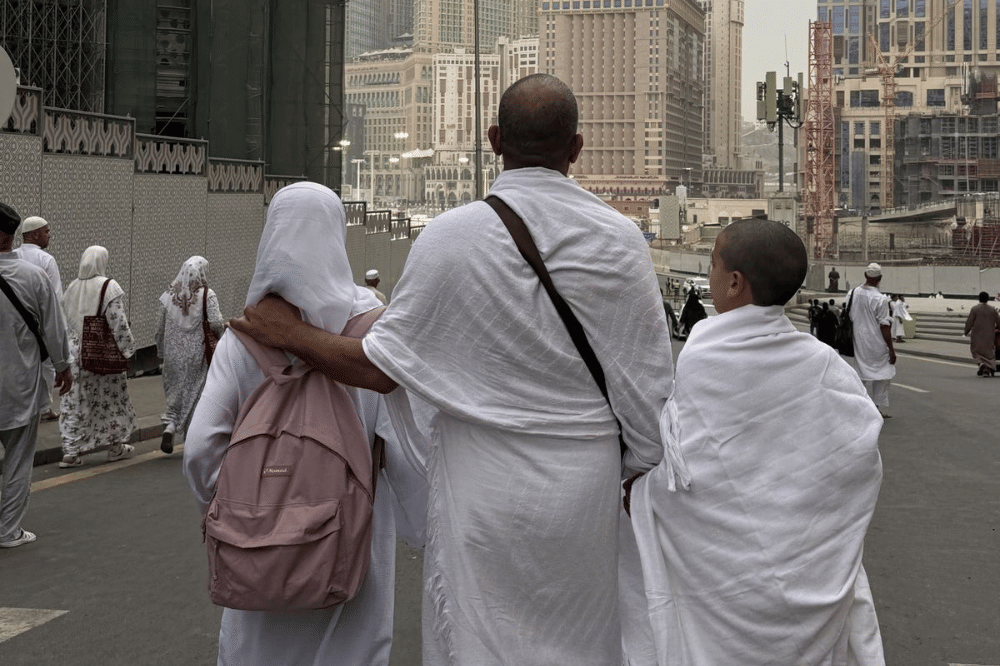 Papa dan kedua anaknya sedang berjalan bersama saat ibadah umroh 