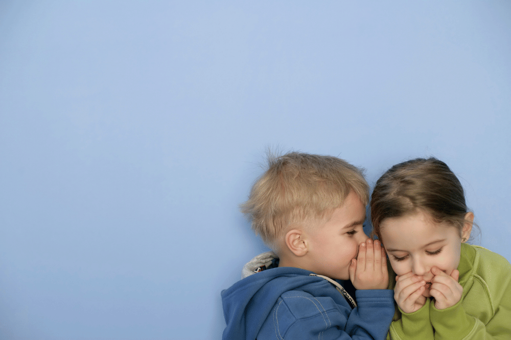 Dua orang anak sedang berbisik