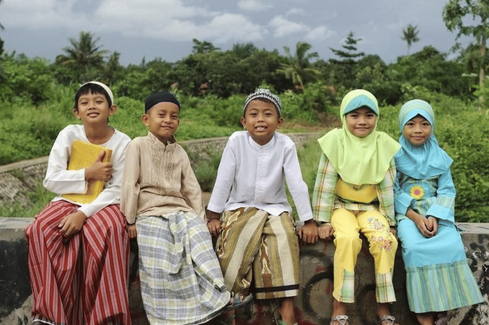 Anak-anak dengan pakaian muslim berpose di depan kamera 