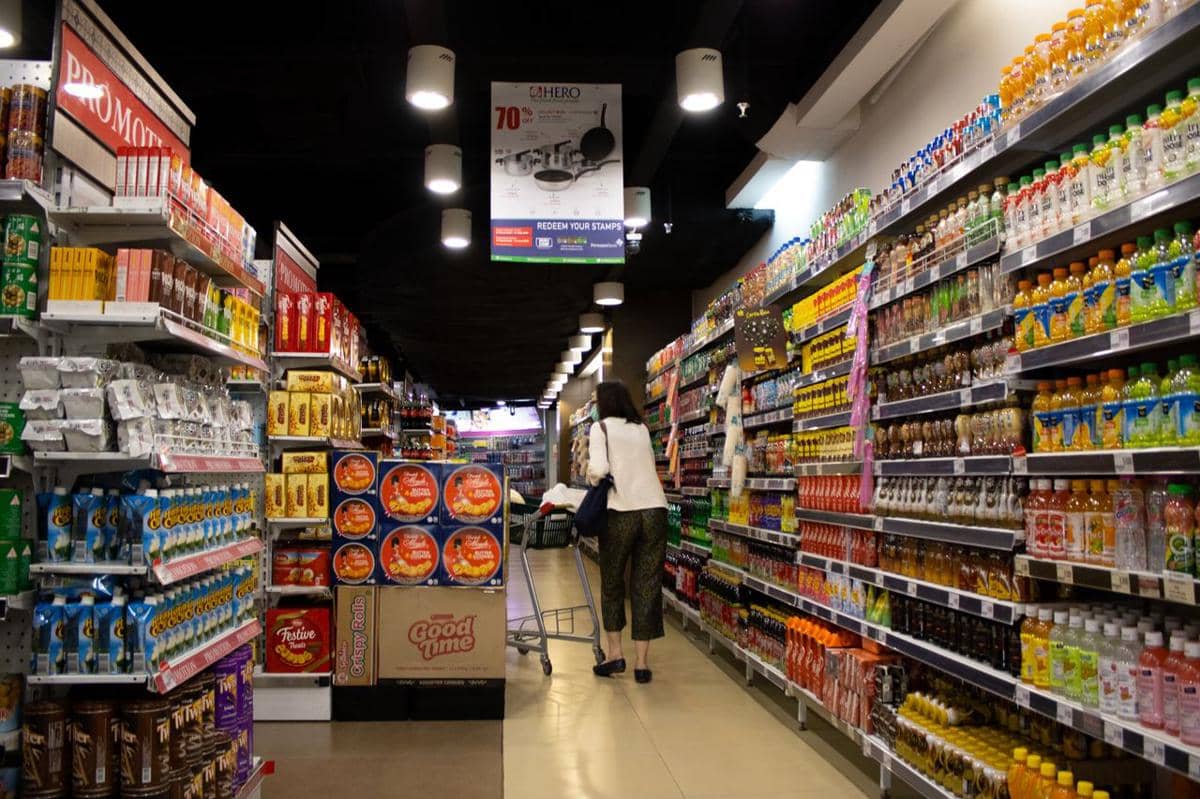 ilustrasi suasana lorong supermarket yang ramai dengan seorang pembeli