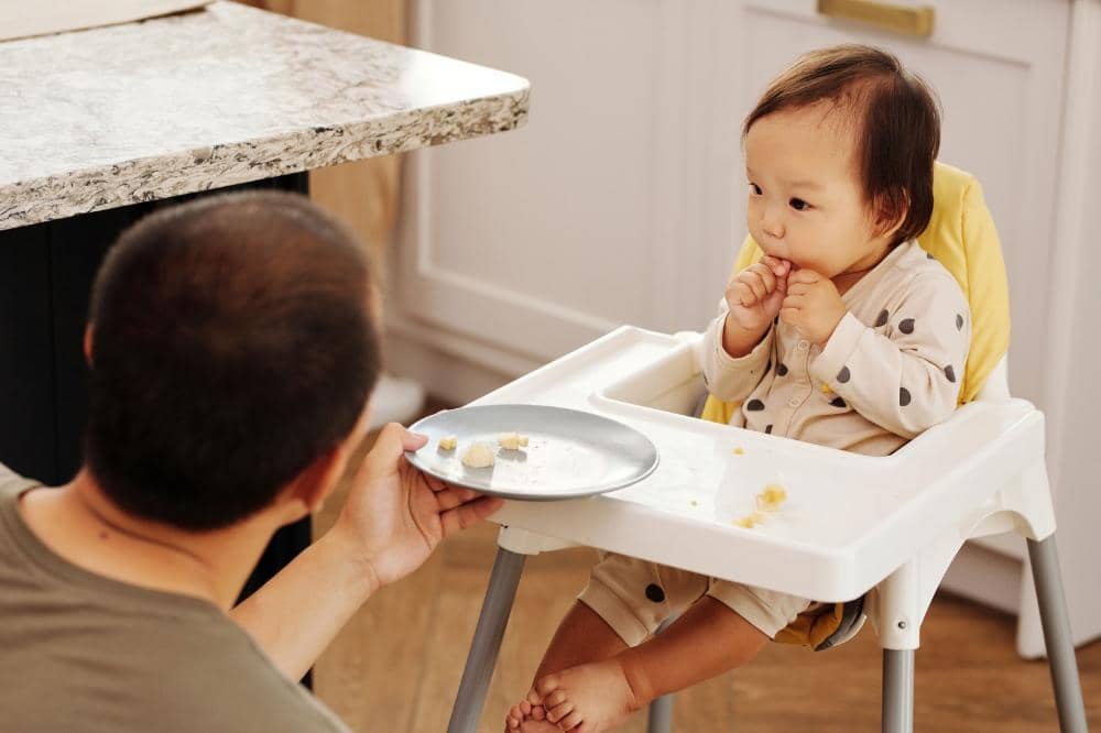 Anak memakan potongan buah segar dengan antusias