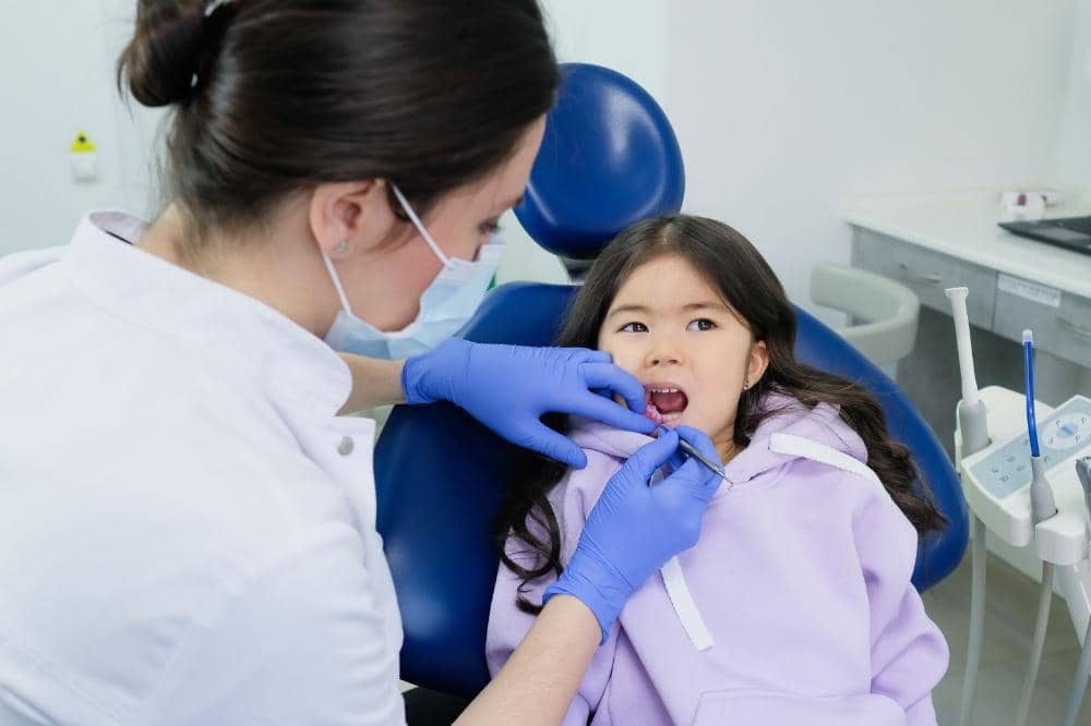 Anak sedang melakukan pemeriksaan gigi dengan dokter gigi
