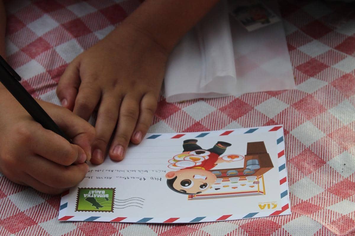 Anak menulis surat Pos untuk anak korban bencana di Sumatra dalam kegiatan Kumpul Piknik Media Menuju CIA Fest 2026 di Jakarta