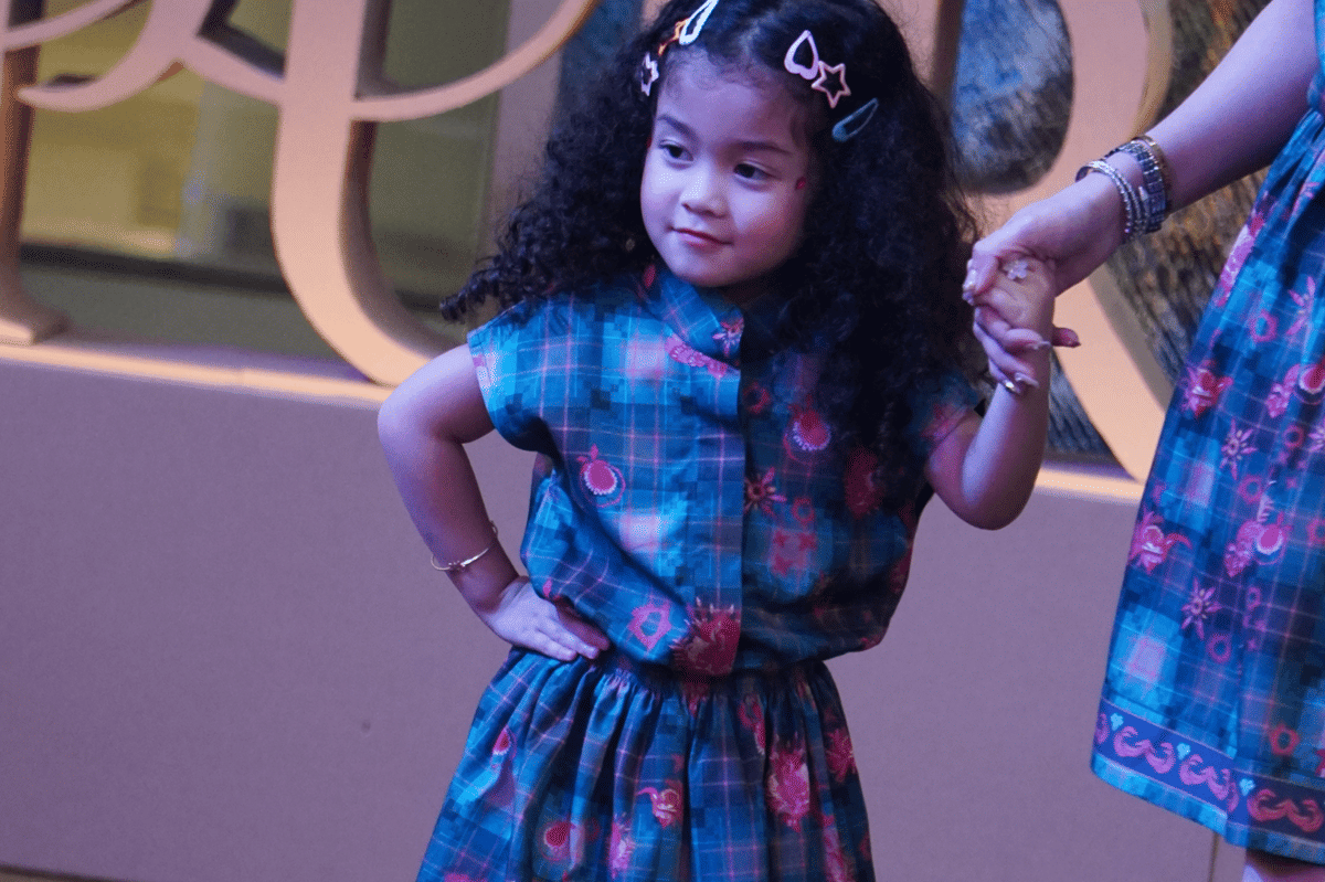 Model cilik tampil dengan percaya diri menampilkan koleksi baru dari Purana