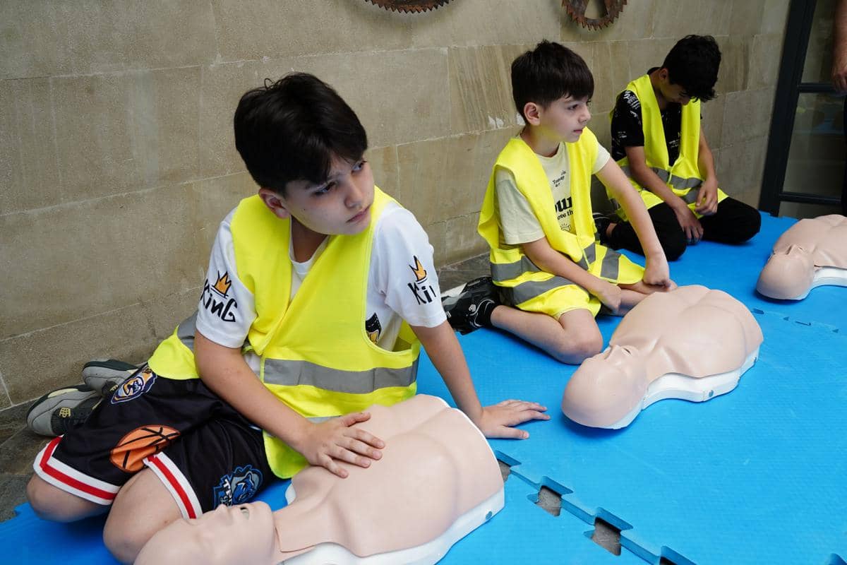 Anak melakukan simulasi CPR pada boneka
