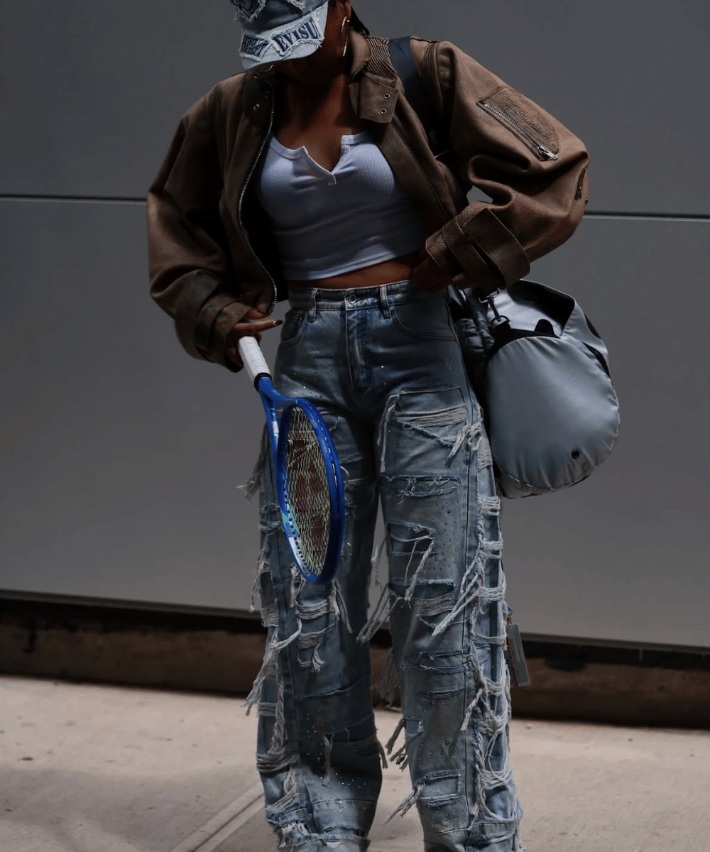 Paduan jaket kulit dan celana ripped jeans bernuansa edgy
