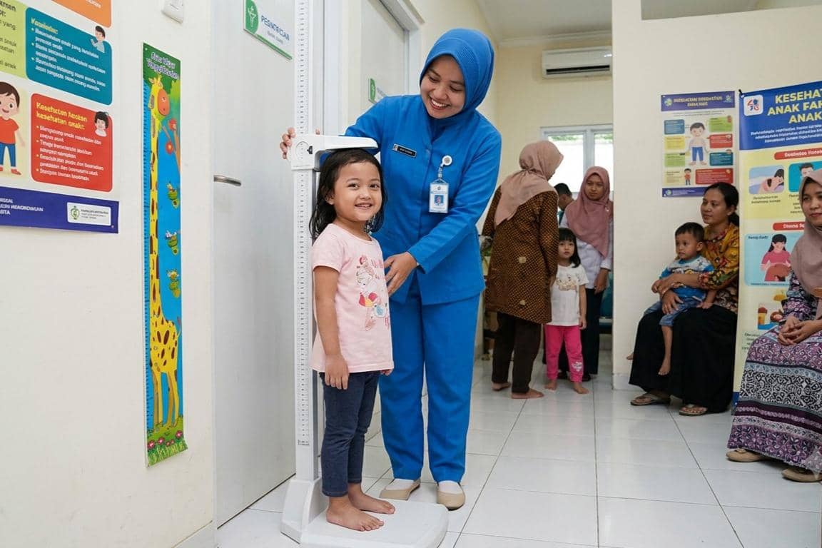 Anak sedang mengukur tinggi di Puskesmas