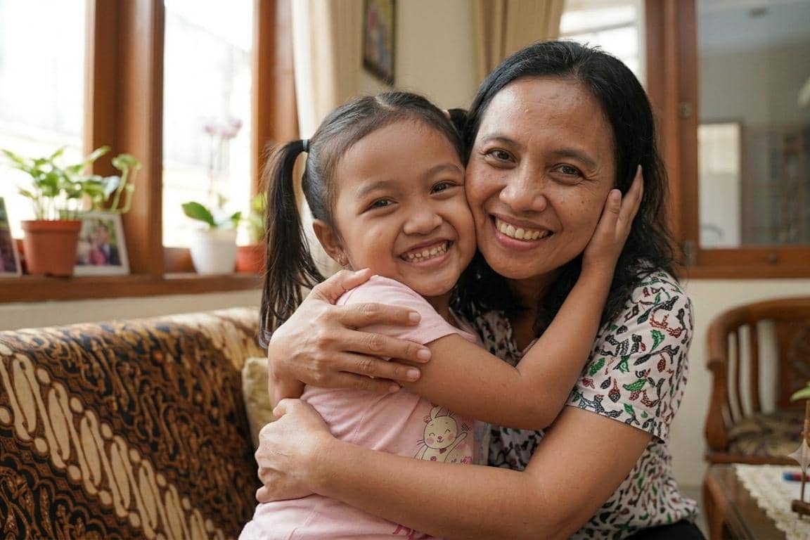 Anak memeluk mama dengan senyuman ceria