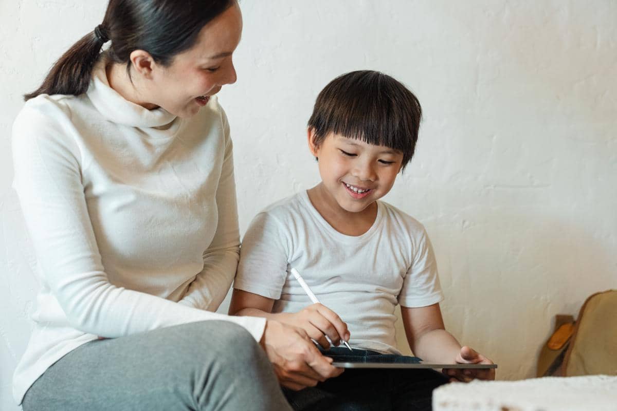 Mama membantu anak laki-laki dengan tabletnya