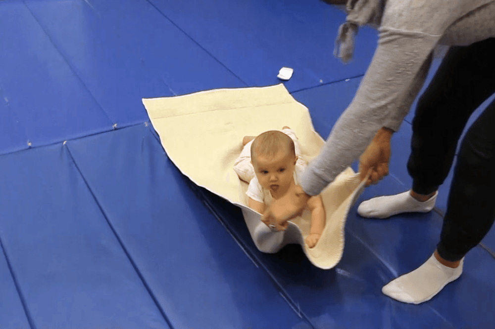 Tummy time dengan tarikan handuk