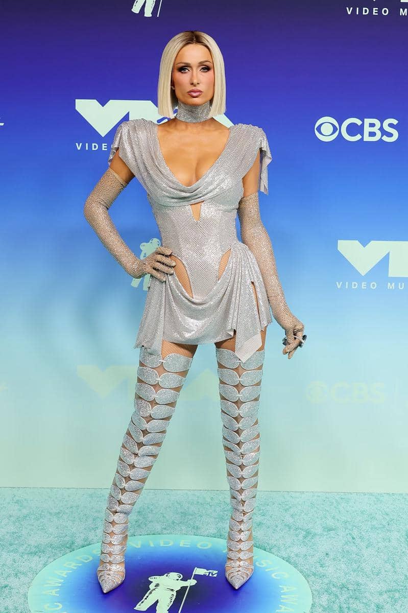 Paris Hilton tampil futuristik dengan dress silver dan boots tinggi