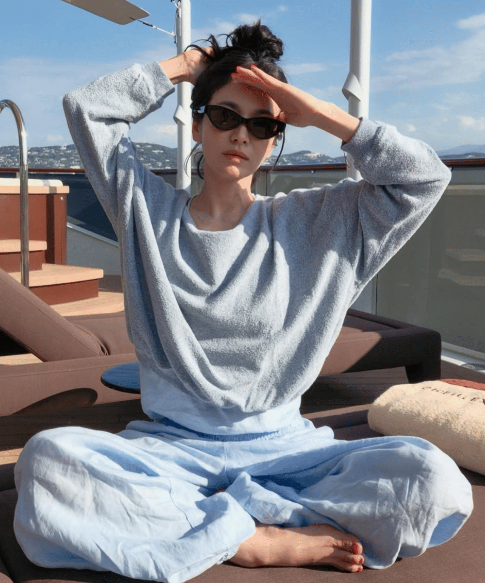 Setwear santai berwarna baby blue dengan gaya rambut bun
