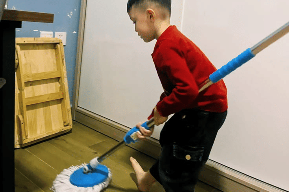 Anak laki-laki sedang mengepel