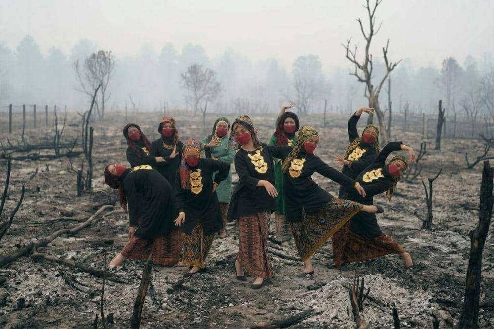 Busana adat hadir di tengah lanskap hutan yang terbakar