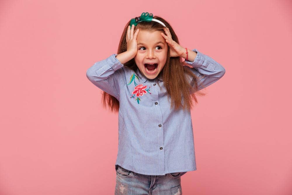 Anak perempuan terlihat emosi sambil memegang kepala kecilnya