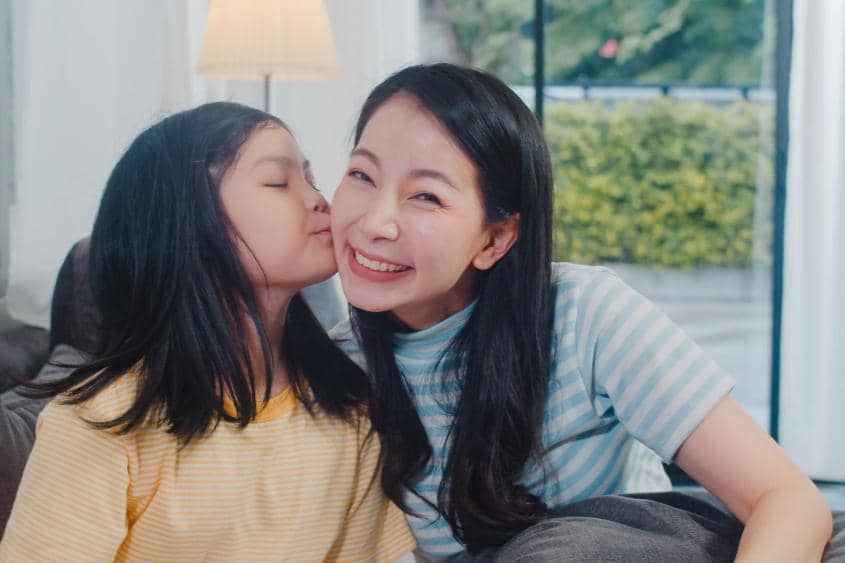 Anak perempuan mencium pipi Mama