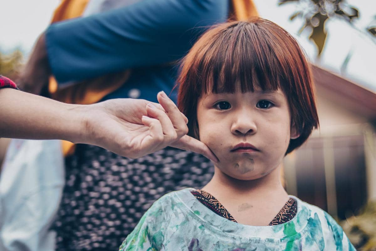 Anak dengan mata berlinang air mata menatap kamera